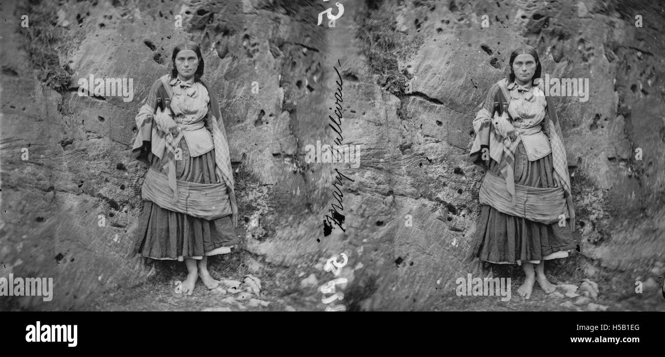 Questo ritratto a figura intera è stato scattato a The Gap of Dunloe, un passo panoramico di montagna nella contea di Kerry, in Irlanda. La fotografia cattura la bellezza naturale della zona, con il suo terreno accidentato e la vegetazione lussureggiante, accanto ai soggetti in abito tradizionale. Foto Stock