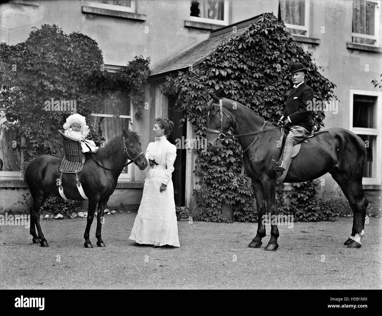 Una scena che raffigura cavalli, acconciature e cappelli, catturando un momento vivace e alla moda. Questo titolo può riferirsi a un evento o a un'immagine che mostra gli stili dell'epoca, con "il vero McCoy" che potrebbe riferirsi all'autenticità nella moda o nello spettacolo. Foto Stock