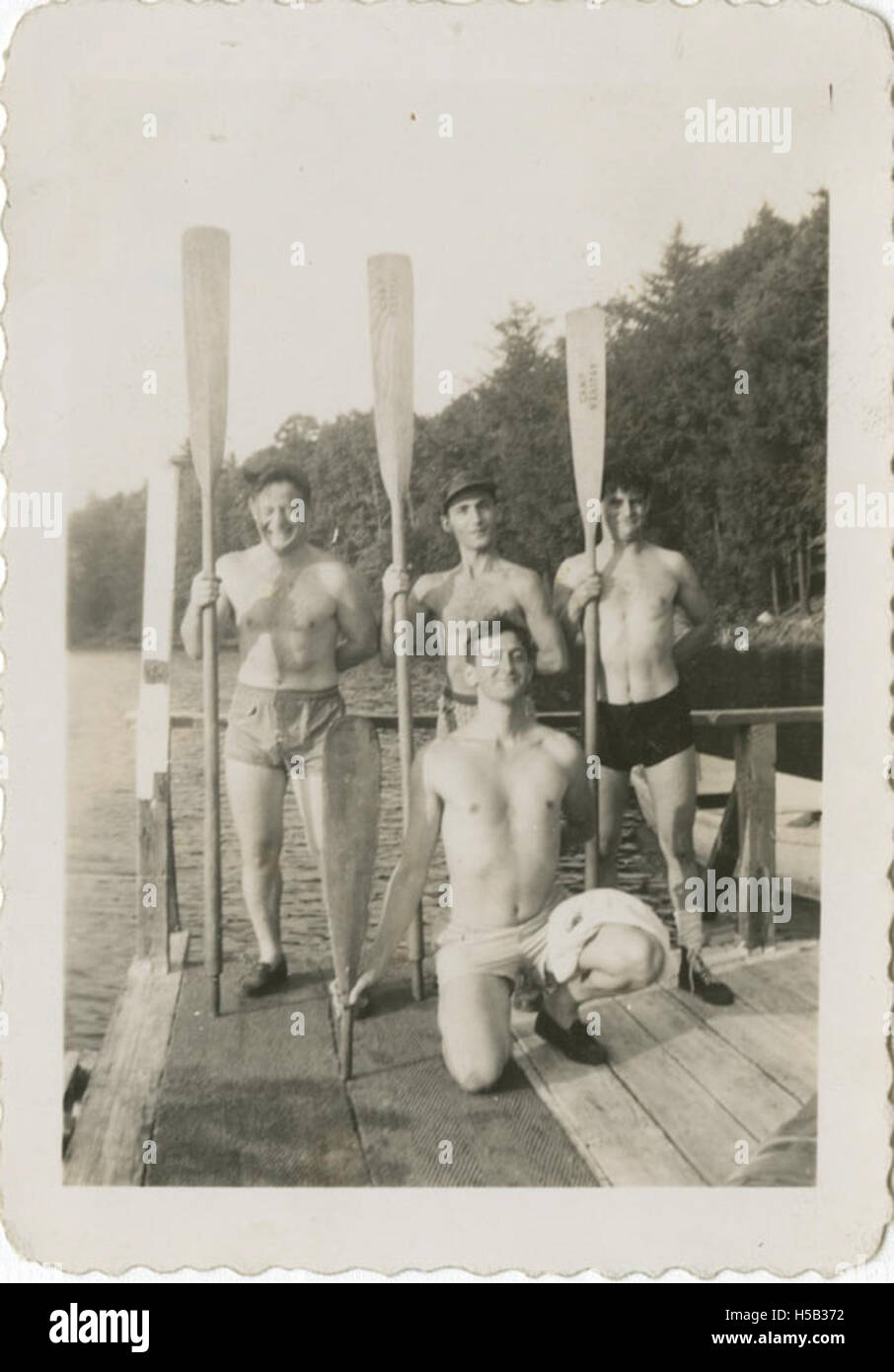 Questa fotografia storica cattura un gruppo di giovani uomini in un campo estivo, probabilmente proveniente dall'Ebraico Orfano Asylum della città di New York. Stanno posando con i remi su un molo, forse come parte di un'attività di canottaggio o acquatica durante la loro esperienza al campo. Foto Stock Questa fotografia storica cattura un gruppo di giovani uomini in un campo estivo, probabilmente proveniente dall'Ebraico Orfano Asylum della città di New York. Stanno posando con i remi su un molo, forse come parte di un'attività di canottaggio o acquatica durante la loro esperienza al campo. Foto Stock