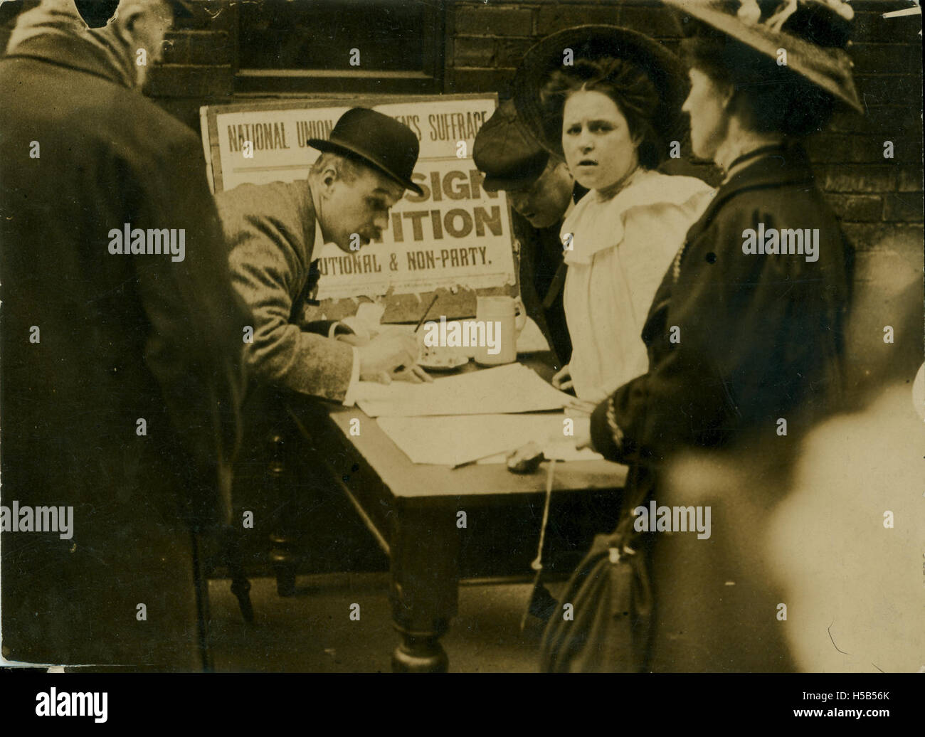 Una fotografia che raffigura un uomo che firma una petizione del 1909 della NUWSS che sostiene il suffragio femminile, riflettendo il sostegno all'inizio del XX secolo per i diritti di voto delle donne nel Regno Unito. Foto Stock