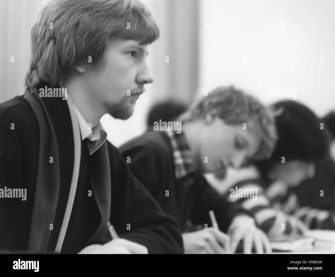L'immagine cattura un gruppo di studenti che frequentano una lezione nel 1981. Mostra l'ambiente in classe del tempo, con gli studenti che ascoltano attentamente il docente. L'aula appare tradizionale, con scrivanie e lavagne, riflettendo le pratiche educative dei primi anni '1980 Foto Stock