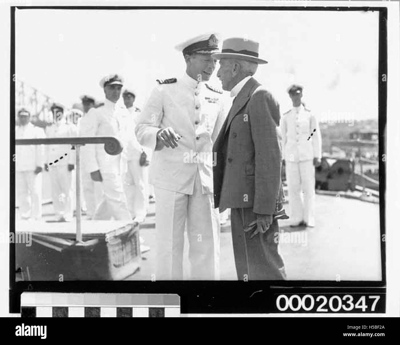 Il capitano John Collins della HMAS Sydney (II) è visto parlare con William Morris 'Billy' Hughes, ministro della Marina, il 10 febbraio 1941. Questa immagine cattura un momento significativo durante la seconda guerra mondiale nella storia navale dell'Australia. Foto Stock