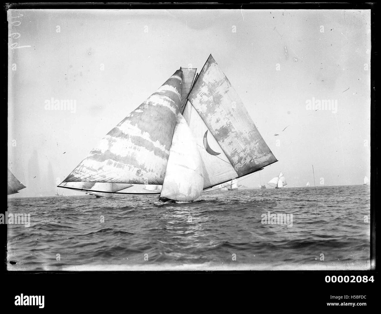 Una fotografia di un 18 piedi, forse il KERIKI, navigando sul porto di Sydney. L'immagine cattura lo sciatore sotto la vela completa, partecipando a una gara o a un evento competitivo nell'iconico porto. Foto Stock