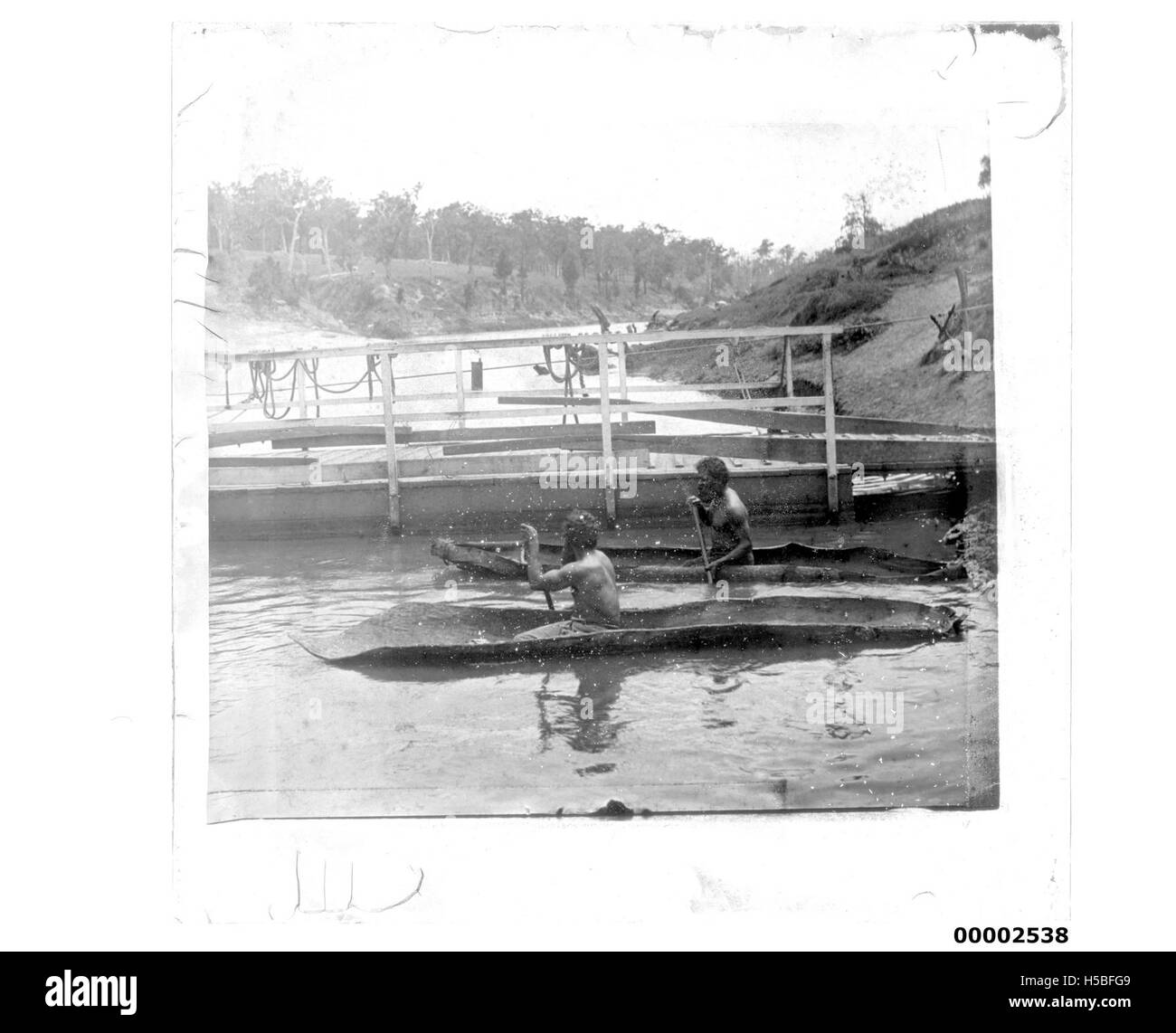 Una fotografia storica del popolo aborigeno nelle tradizionali canoe di corteccia, che mostra i loro metodi di trasporto e le pratiche culturali. L'immagine illustra il collegamento tra la comunità aborigena e le moto d'acqua utilizzate per i viaggi e la pesca. Foto Stock