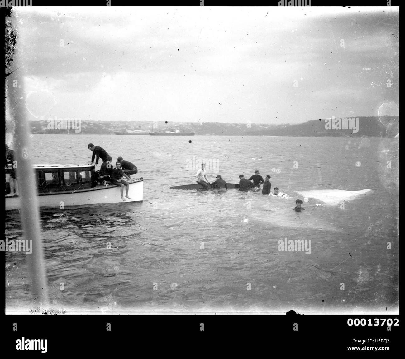 Una fotografia che documenta un equipaggio di un salmone paludoso salvato da un lancio a motore, evidenziando le operazioni di salvataggio marittimo e le misure di sicurezza impiegate nelle emergenze nautiche all'inizio del XX secolo. Foto Stock