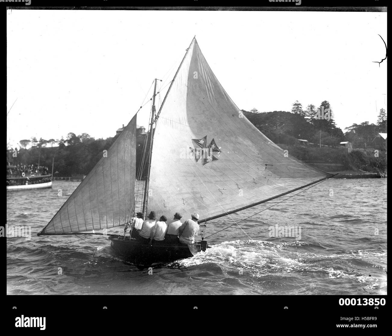 La fotografia mostra uno yacht di 10 piedi vicino a Balmain, nel porto di Sydney. L'immagine cattura il piccolo yacht in azione sull'acqua, sottolineando lo sport della navigazione nel porto di Sydney durante l'inizio del XX secolo. Foto Stock