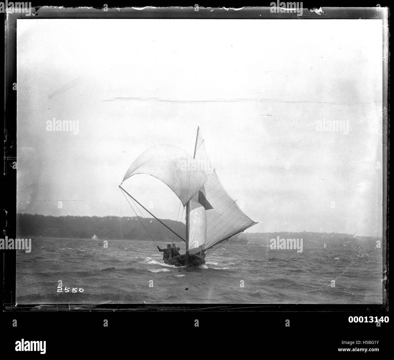 Una fotografia di una barca a vela di 18 piedi nel porto di Sydney, che cattura l'iconica via d'acqua australiana e il suo utilizzo per la navigazione competitiva durante una gara o un evento. Foto Stock