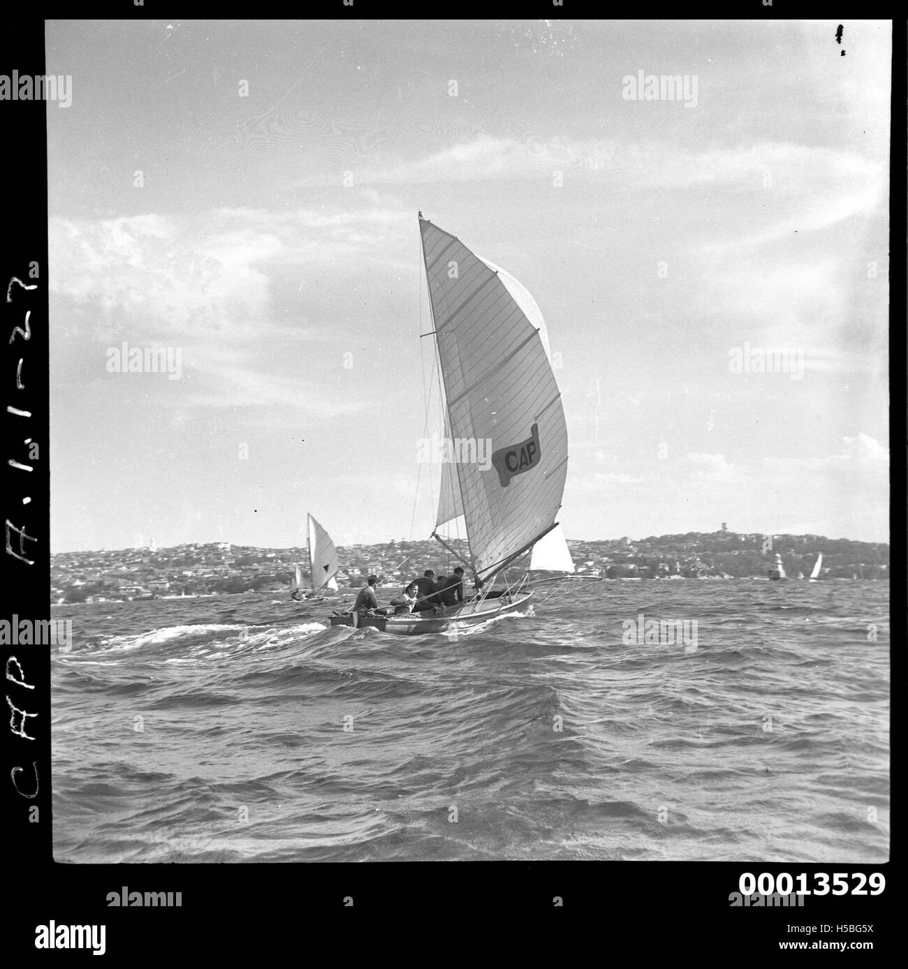Una barca a vela di 18 piedi, chiamata CAP, è vista sotto la vela completa nel porto di Sydney. Questa barca a vela competitiva fa parte di una serie di corse in uno dei porti più famosi dell'Australia. Foto Stock