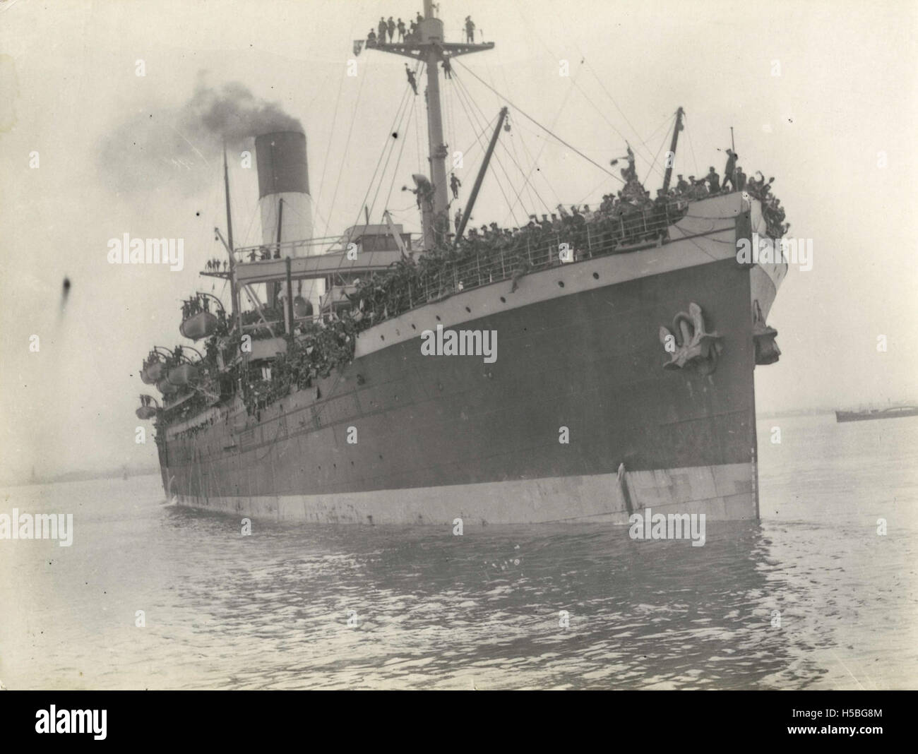 Il troopship Nestor parte da Melbourne, trasportando soldati durante un'operazione militare. Questa fotografia cattura la nave in movimento, sottolineando il suo ruolo nel trasporto di personale militare, probabilmente durante la guerra, all'inizio del XX secolo. Foto Stock