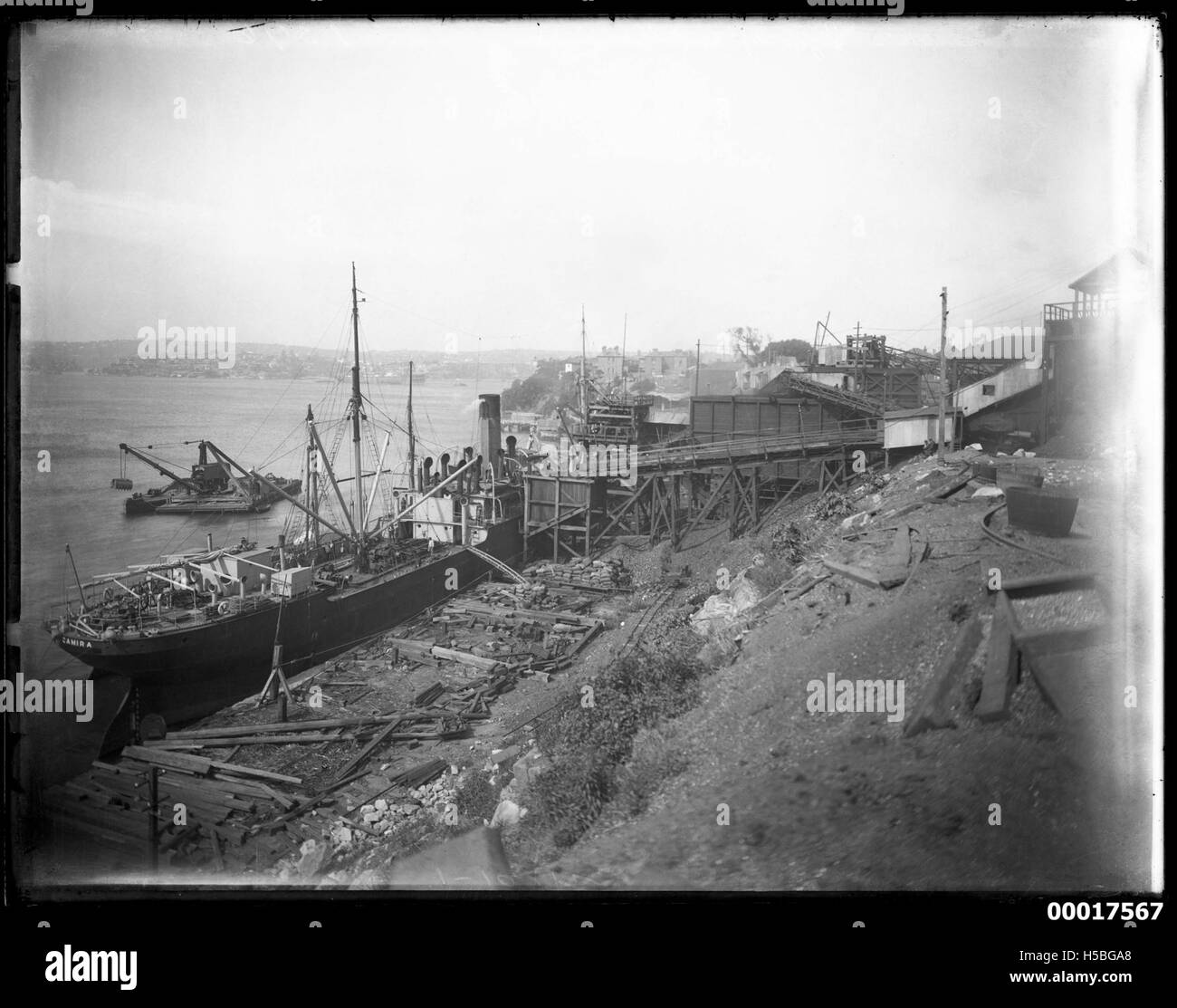 La nave cargo interstatale CAMIRA è probabilmente raffigurata a Balmain, Sydney. Navi cargo come la CAMIRA erano comunemente usate per trasportare merci tra gli stati australiani, e l'immagine mostra la storica attività marittima nei porti di Sydney. Foto Stock