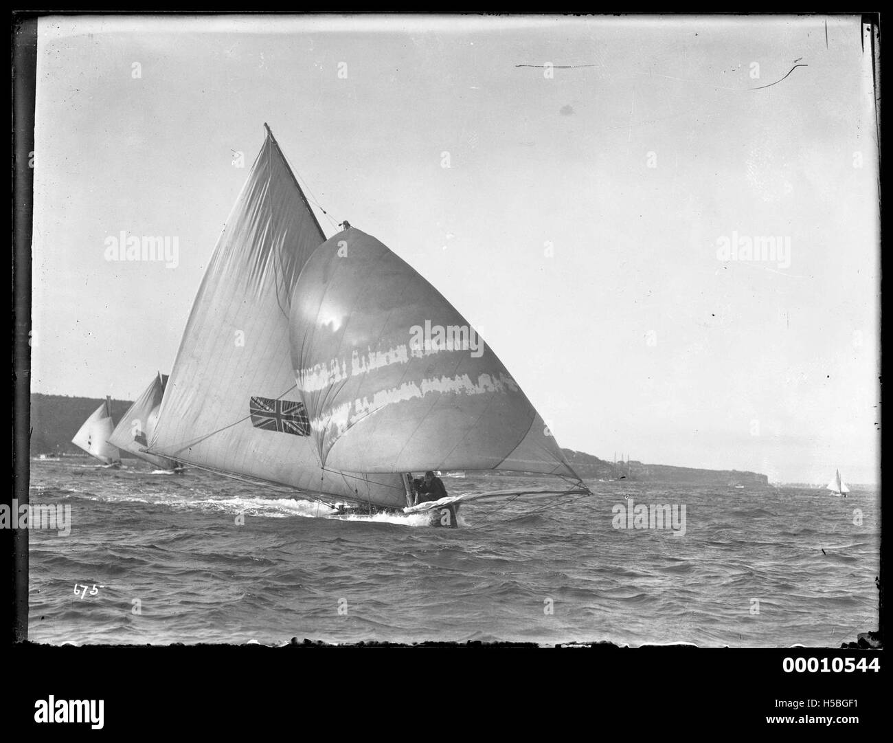 Lo yacht, potenzialmente AUSTRALIANO II o AUSTRALIANO III, viene mostrato a vela nel porto di Sydney, dimostrando la forte tradizione marittima della regione e la cultura velica competitiva. Foto Stock