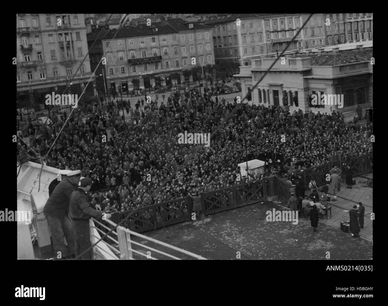 Questa immagine cattura una folla a Trieste, in Italia, mentre la nave CASTEL VERDE parte per l'Australia nel periodo 1953-1954. La nave è stata coinvolta nel trasporto di migranti, una parte dei movimenti migratori post-bellici in Australia. Foto Stock