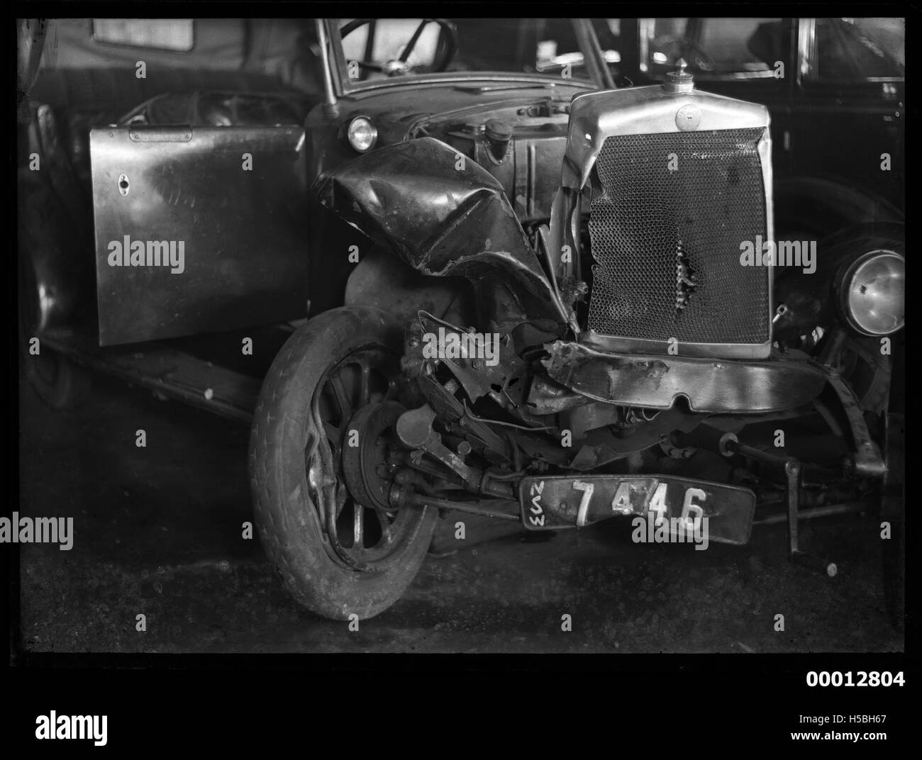 Viene mostrata una vettura Morris Cowley con targa NSW "7446", danneggiata probabilmente a causa di un incidente. La vettura riflette la storia automobilistica e l'uso di targhe come identificazione per i veicoli nel nuovo Galles del Sud. Foto Stock
