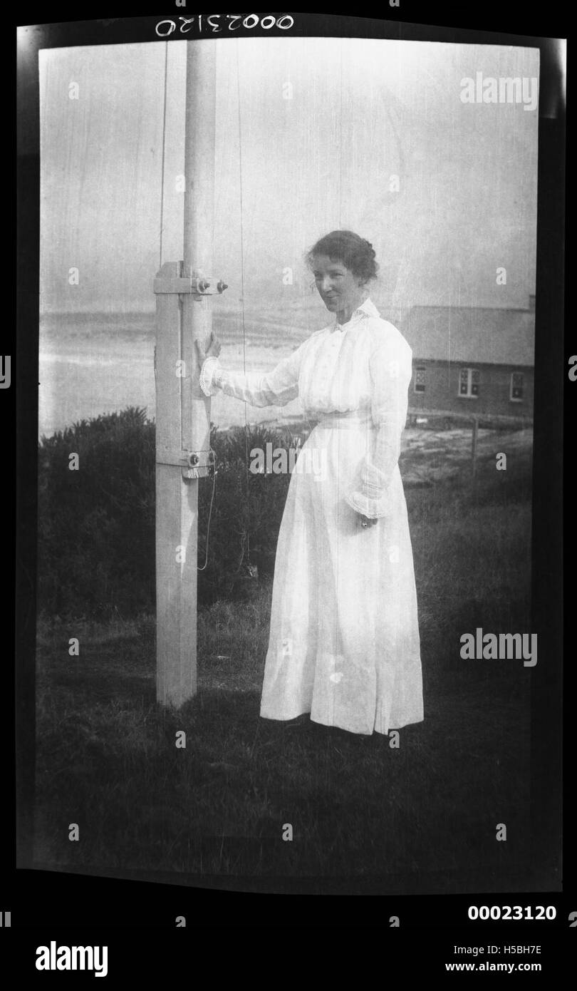 Una donna non identificata, probabilmente collegata al capitano Edward R. Sterling, viene vista in piedi accanto a un palo. Questa immagine cattura un momento probabilmente legato a eventi storici durante l'inizio del XX secolo. Foto Stock