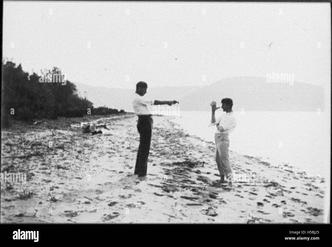 Una scena che mostra le persone che si godono una giornata in spiaggia, impegnandosi in attività ricreative, probabilmente a partire dalla metà del XX secolo. Foto Stock