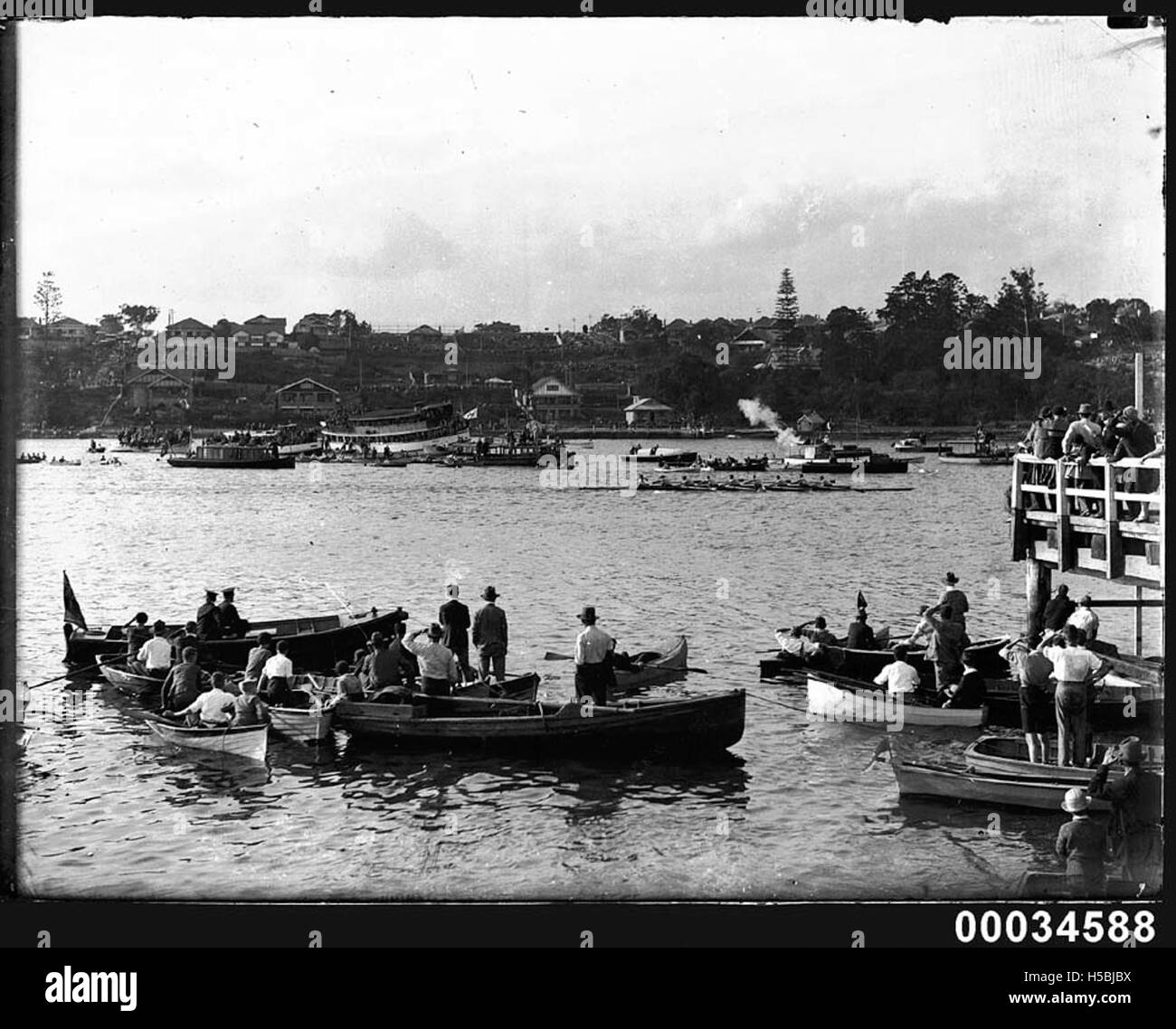 Una gara di canottaggio che si tiene in un porto è spesso un evento competitivo in cui squadre o singoli remi su un percorso prestabilito, spesso come parte di un festival o di una competizione locale. Questo evento mette in evidenza lo sport del canottaggio e il suo legame con le comunità marittime. Foto Stock