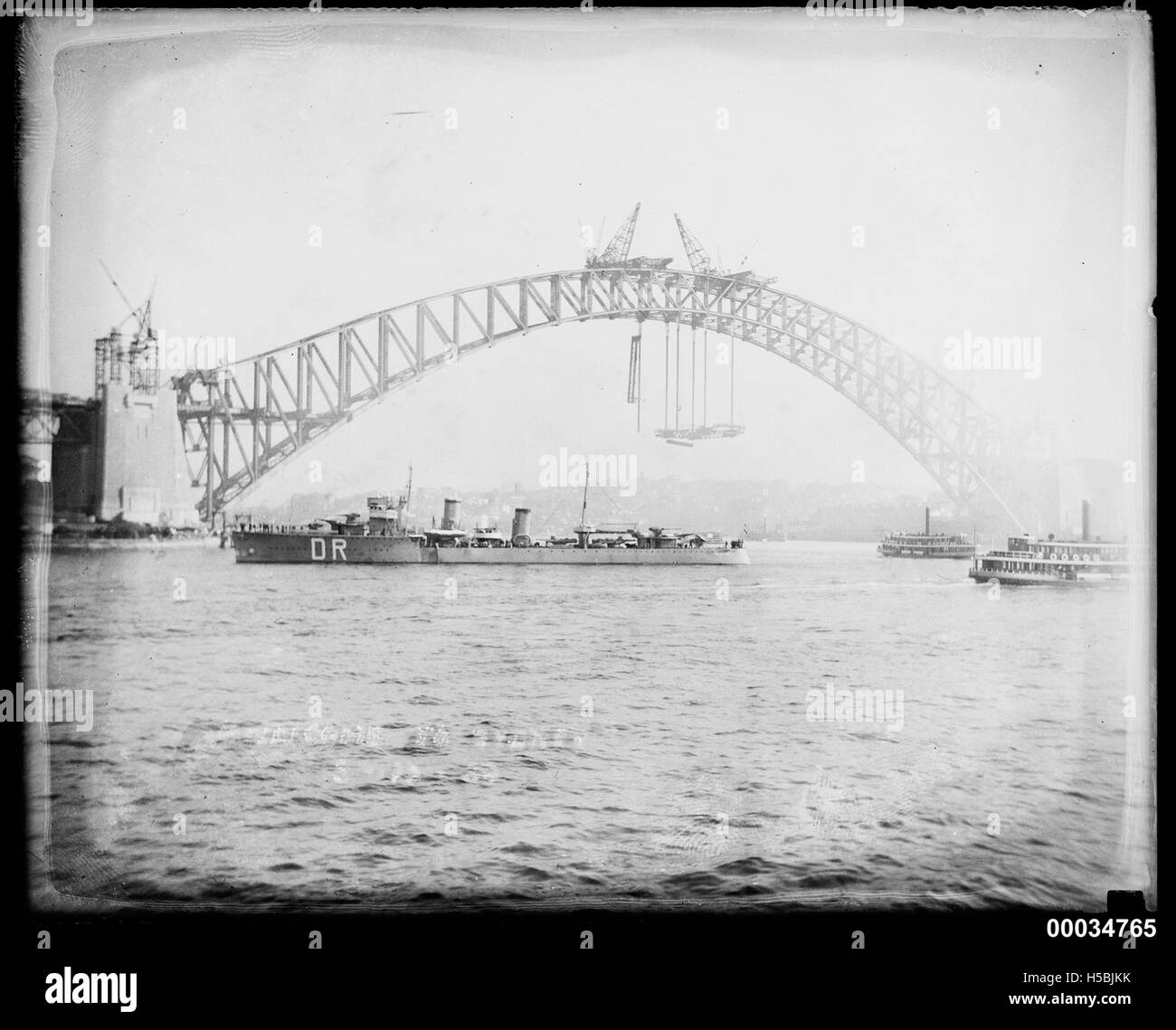 L'incrociatore olandese HNLMS De Ruyter è visto vicino al Sydney Harbour Bridge il 3 ottobre 1930. Questa nave faceva parte della Royal Netherlands Navy e l'immagine evidenzia la presenza della nave nell'iconico porto di Sydney durante la sua visita in Australia. Foto Stock