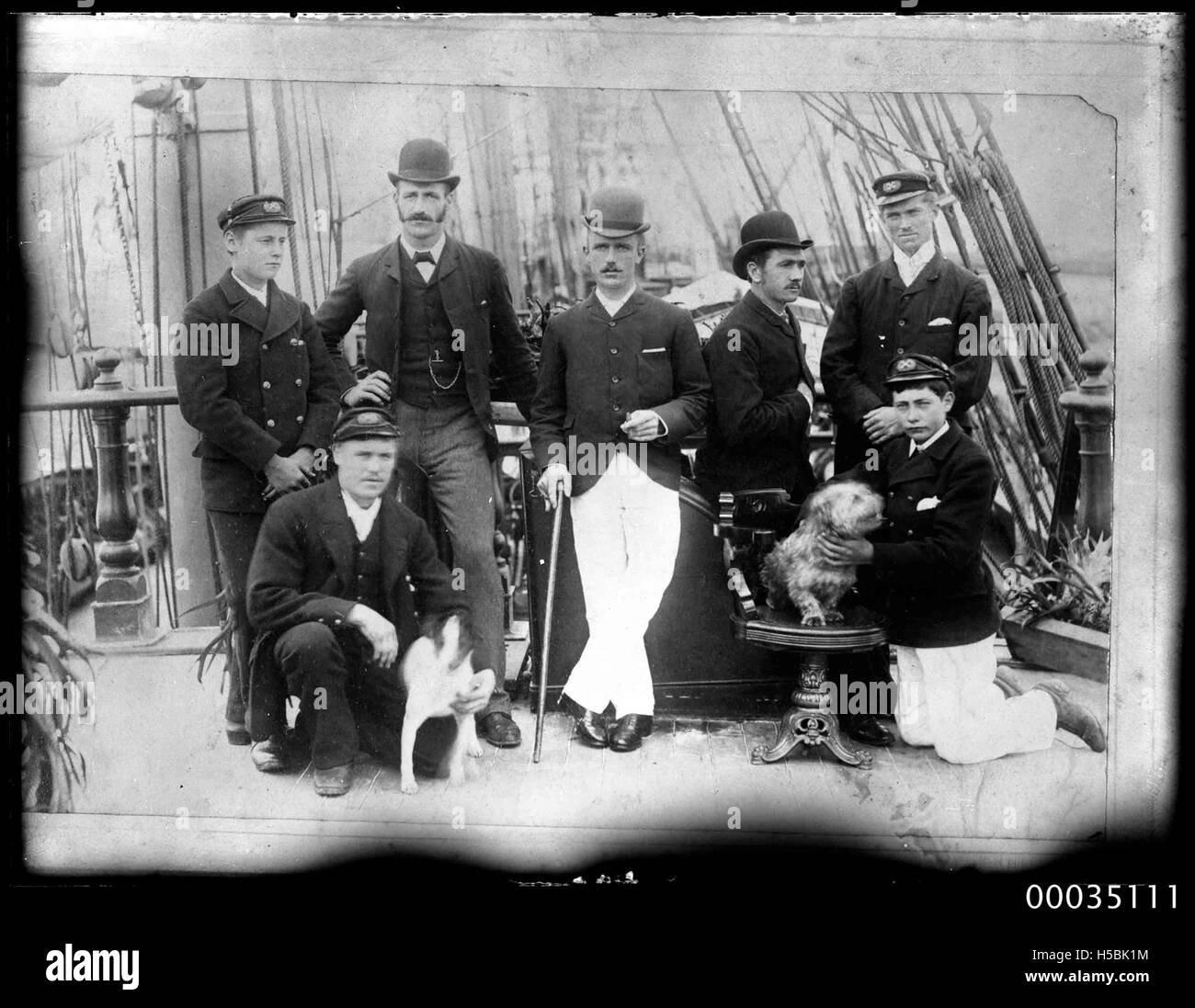 Ritratto di gruppo di sette uomini in posa sul ponte di una nave, 1890-1920 Foto Stock