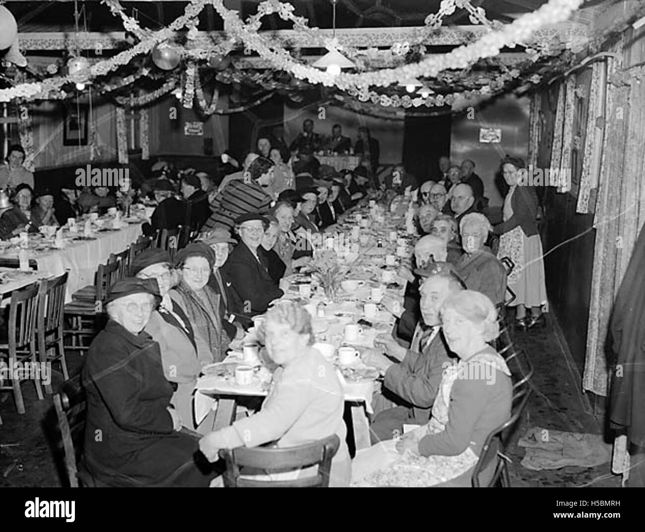 Una fotografia o un riferimento a una festa di Capodanno tenuta dall'Oswestry Old Folk's Club, che riunisce membri anziani della comunità per una festa di festa. Foto Stock