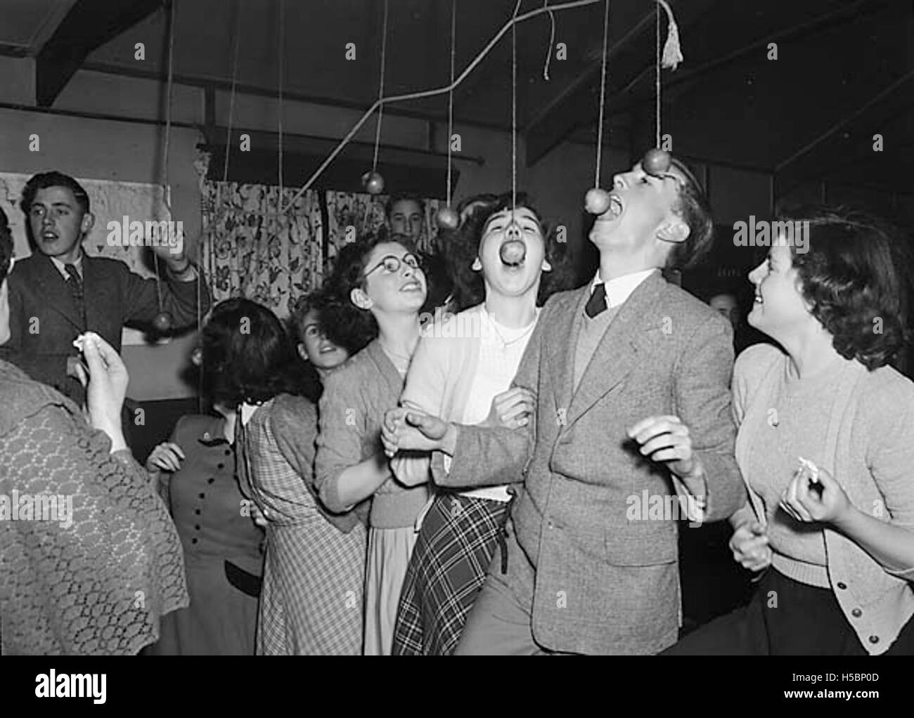 Ad una festa di Halloween a Ditherington, si è svolto il tradizionale gioco del mele-bobbing. I partecipanti hanno tentato di catturare le mele che galleggiano in un bacino pieno d'acqua, una popolare attività di Halloween nel Regno Unito, riflettendo lo spirito festivo dell'evento. Foto Stock