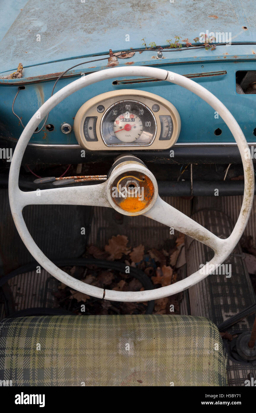 Il volante e il tachimetro di un vecchio e arrugginito auto abbandonate Foto Stock