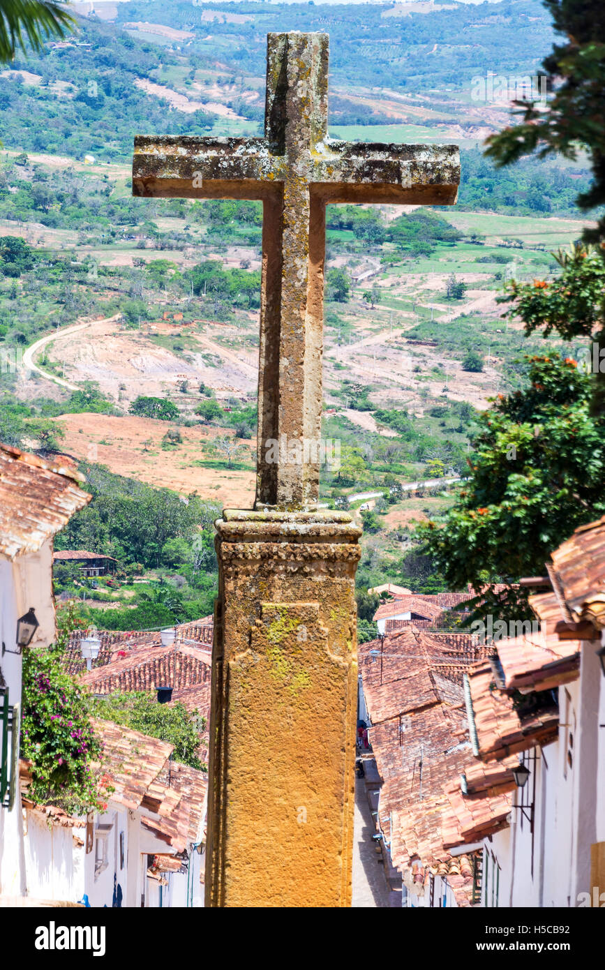 Croce di pietra con la città coloniale di Barichara, Colombia al di sotto di Foto Stock