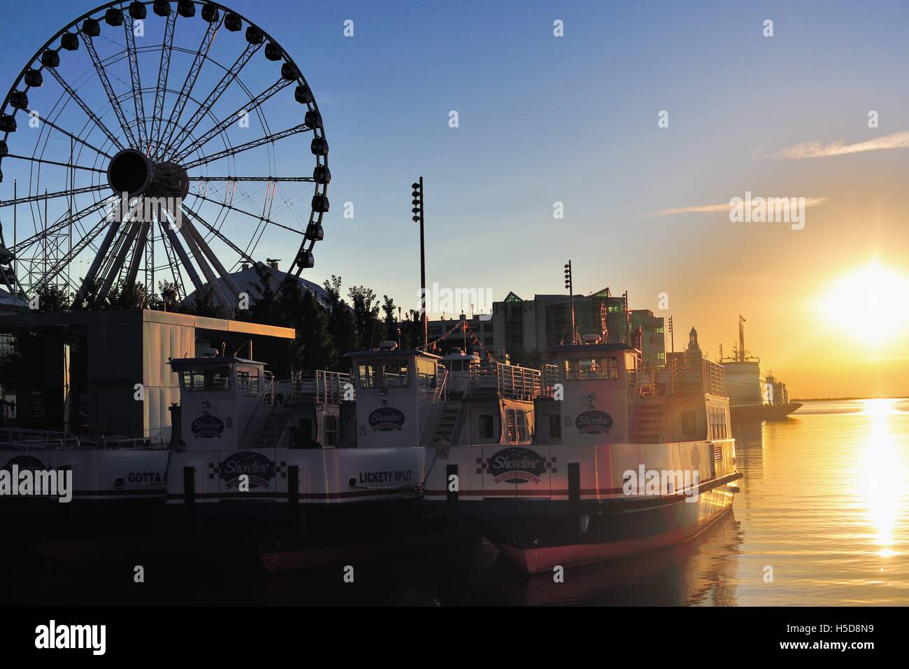 Il sole sorgere riflettendo sull'acqua taxi legato lungo Chicago il Navy Pier su una tarda mattina d'estate. Chicago, Illinois, Stati Uniti d'America. Foto Stock