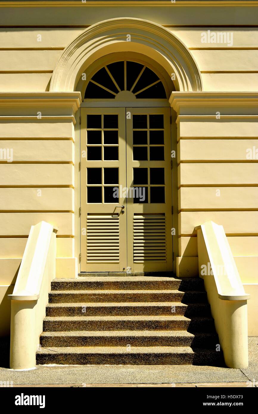 Classico stile coloniale portale ad arco con finestre francesi e gradini in pietra nel quartiere storico civico del centro cittadino di Singapore Foto Stock