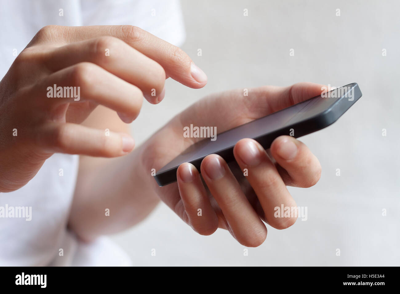 Donna mani toccano smartphone sfondo luminoso, primo piano Foto Stock
