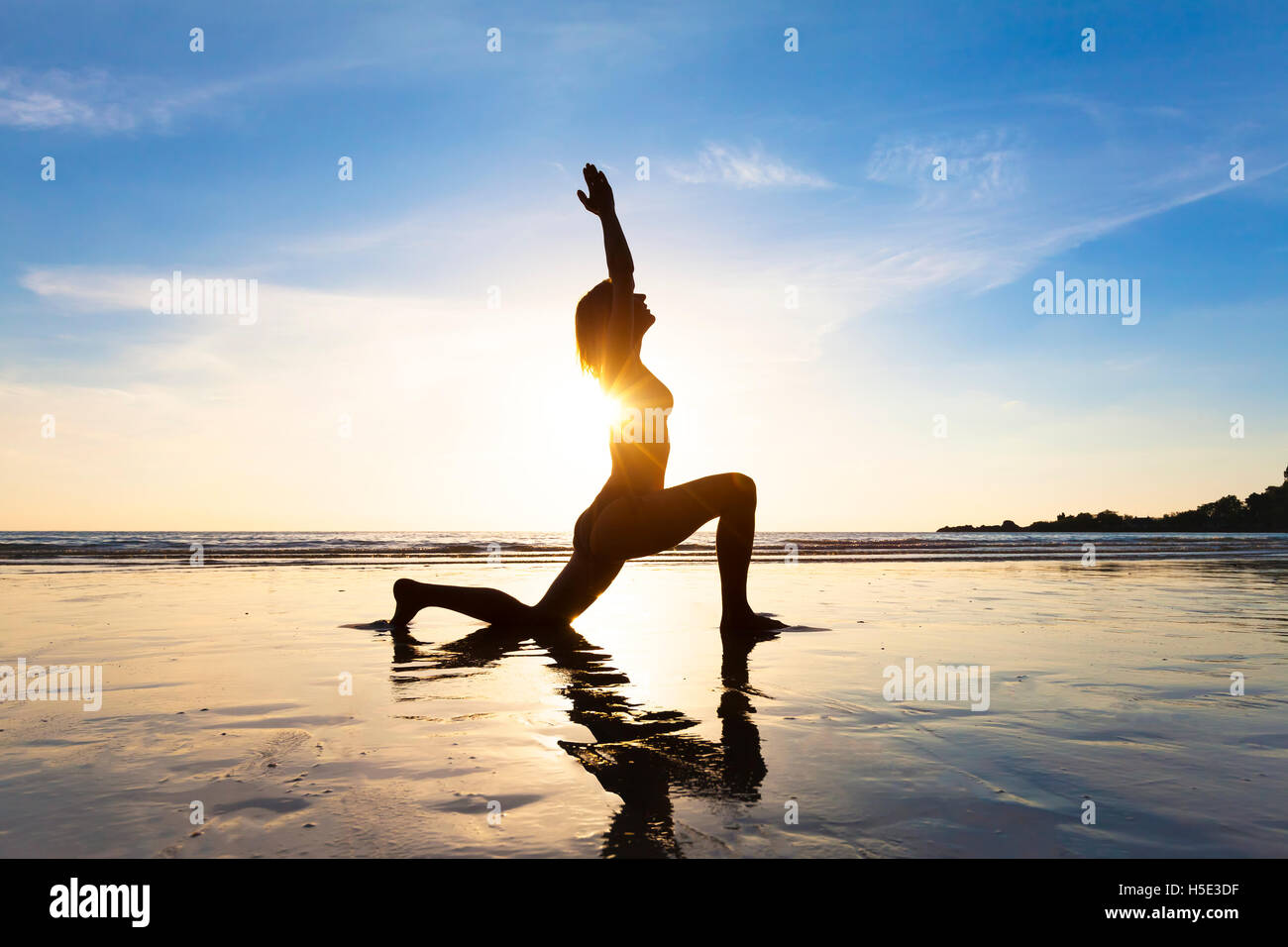 Montare la giovane donna a praticare yoga sulla spiaggia di sunrise per uno stile di vita sano Foto Stock