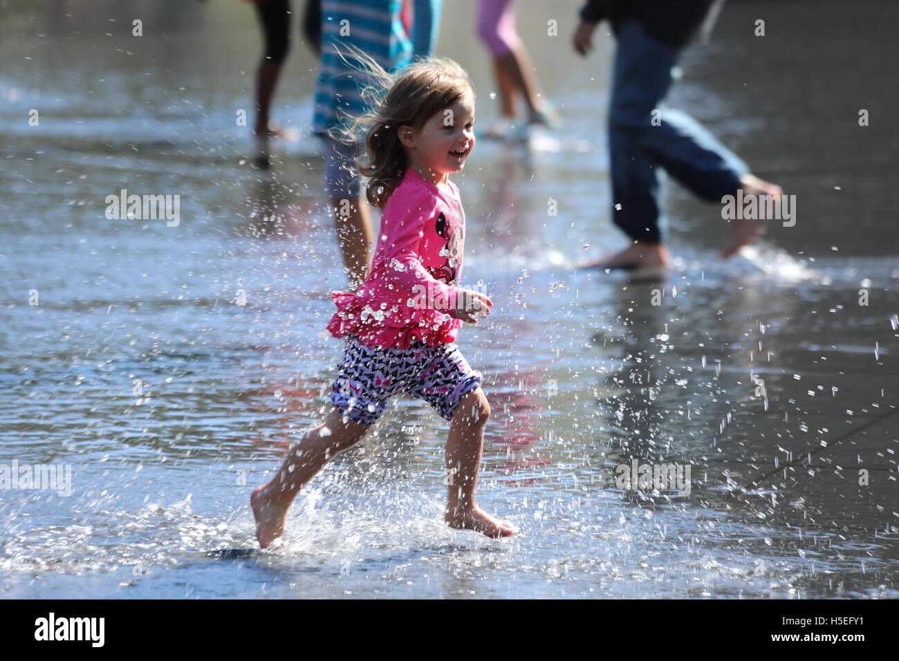 Bambina in esecuzione in acqua. Foto Stock