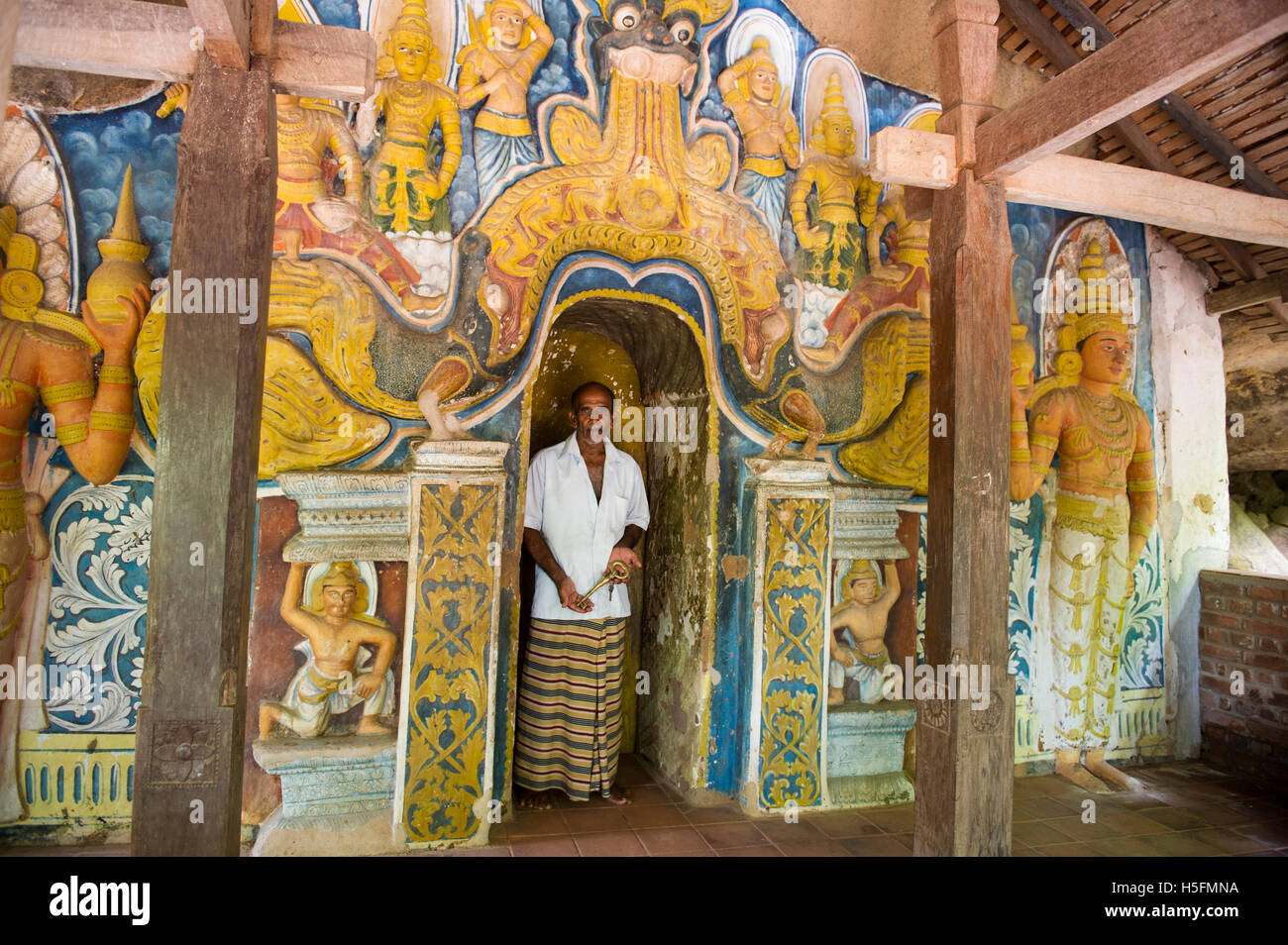 Attenzione introduttore all'entrata di un antico tempio nella grotta, foresta Raswehera monastero, Sasseruwa, Sri Lanka Foto Stock