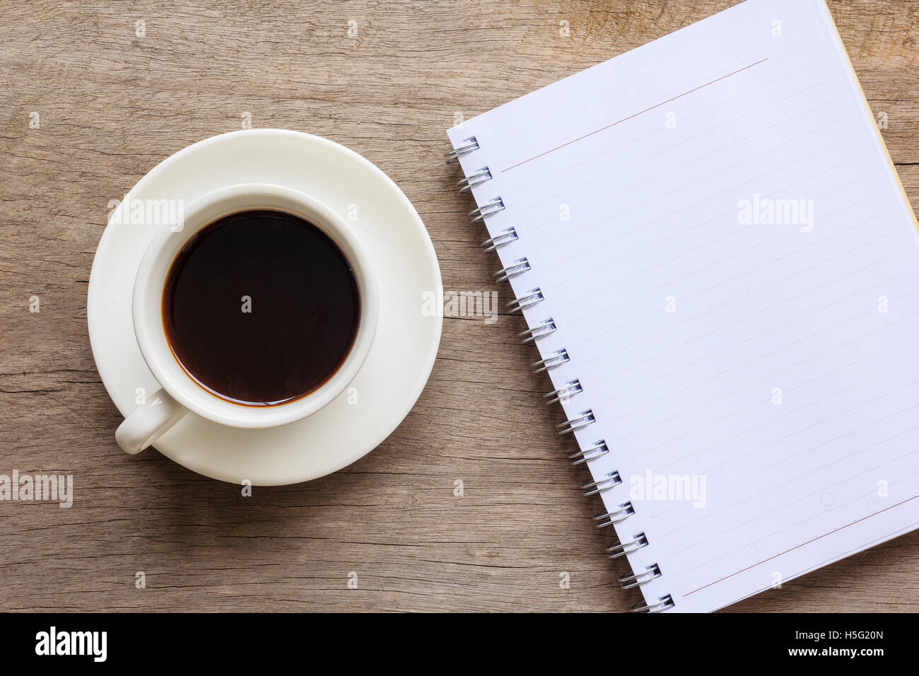 Vista superiore e la chiusura del desktop di legno con notebook e la tazza di caffè. Foto Stock