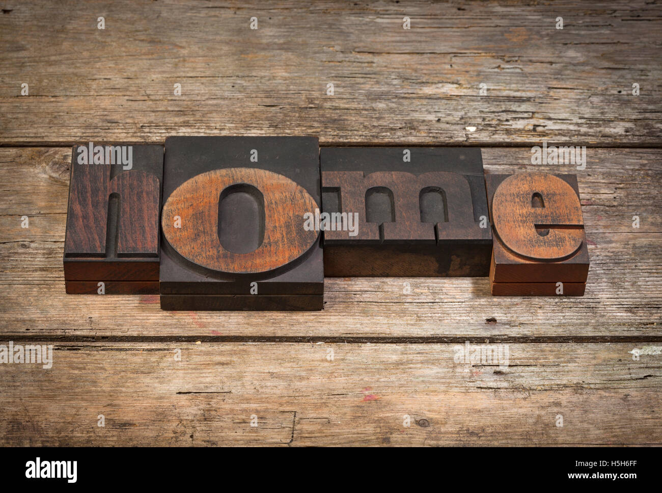 Home, la parola scritta con l'annata tipografia su blocchi di legno rustico sfondo Foto Stock