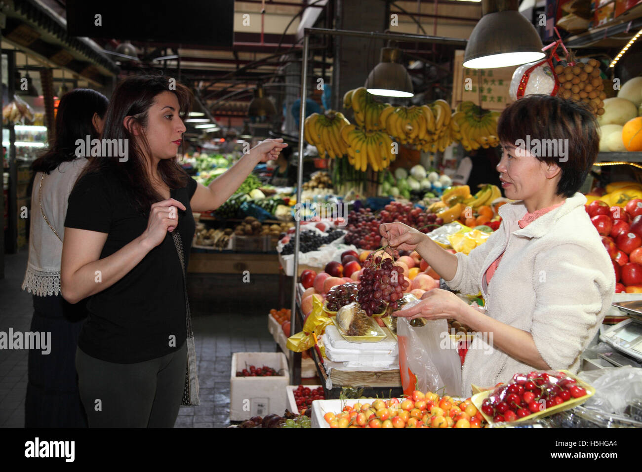 Un colorato di verdura e di mercato della frutta nell'area Tianzifang, qui una donna argentina acquista alcune uve a frutta stand. Shanghai. Foto Stock