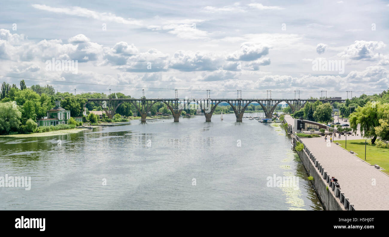 Alta arcuata di un ponte ferroviario in calcestruzzo di fronte fiume Dnieper nella città Dnepropetrovsk. Foto Stock