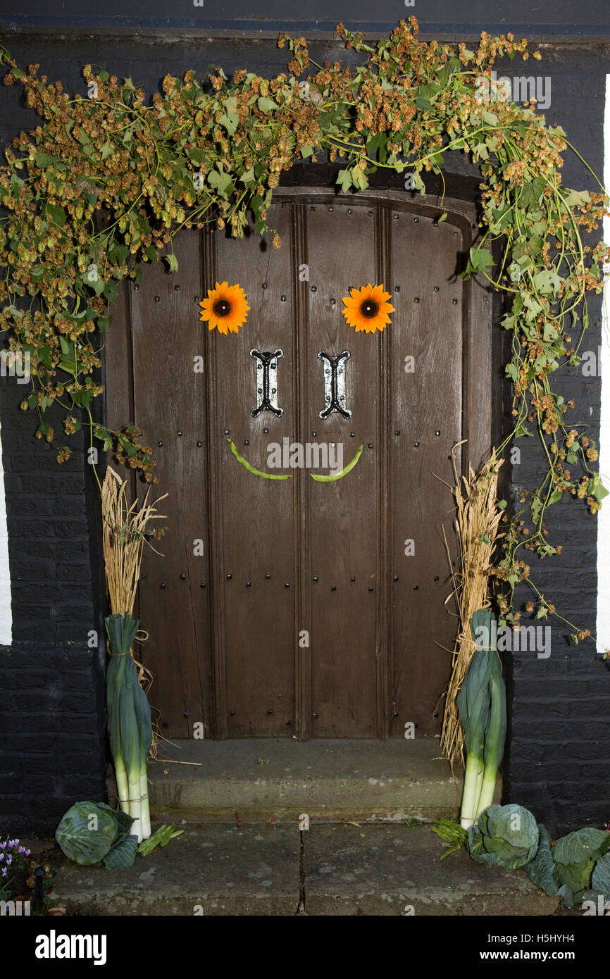 Regno Unito, Inghilterra, Cheshire, a Siddington, Chiesa di Tutti i Santi, Harvest Festival, girasoli e fagioli runner faccia sorridente sul porta occidentale Foto Stock