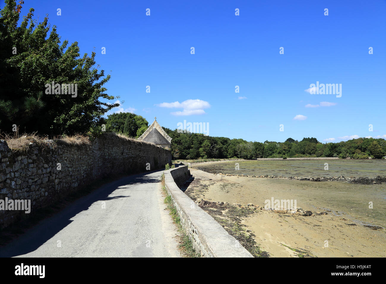 Strada costiera e la cappella a Brouel, Ile aux Moines, Morbihan, in Bretagna, Francia Foto Stock
