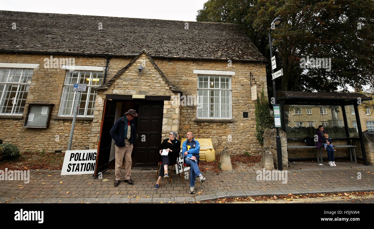 Gli elettori al di fuori di un seggio nel villaggio di Bampton come voti continua a Witney per elezione in Oxfordshire, chiamato dopo che David Cameron uscire la sua sede il mese scorso, insistendo sul fatto che non voleva diventare un 'distraction' alla onorevole può mentre ha stabilito se stessa e a Downing Street. Foto Stock
