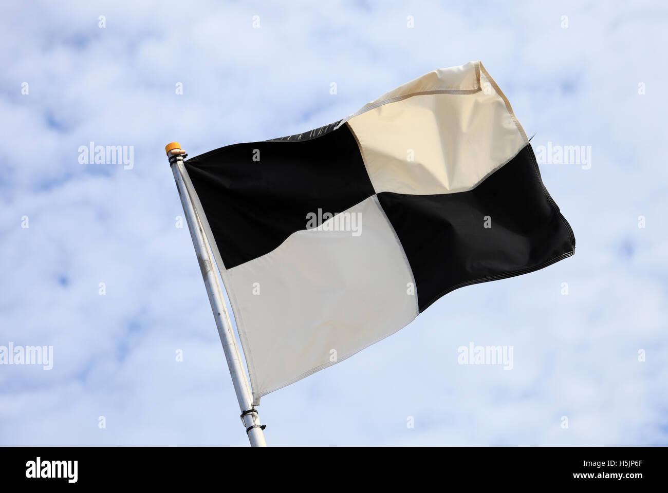 In bianco e nero sotto la bandiera a scacchi al mare. Foto Stock