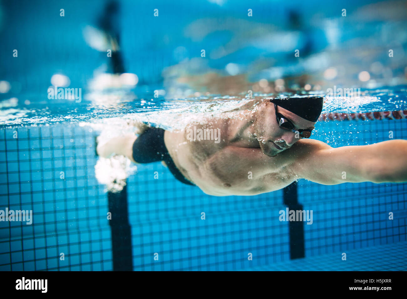 Ripresa subacquea professionale atleta maschio di nuoto in piscina. L'uomo nuotatore in azione. Foto Stock