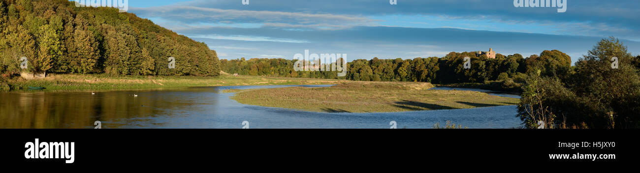 Il castello di Norham bagnata nel tardo pomeriggio di sole, il più pericoloso posto in Inghilterra e il fiume Tweed. Foto Stock