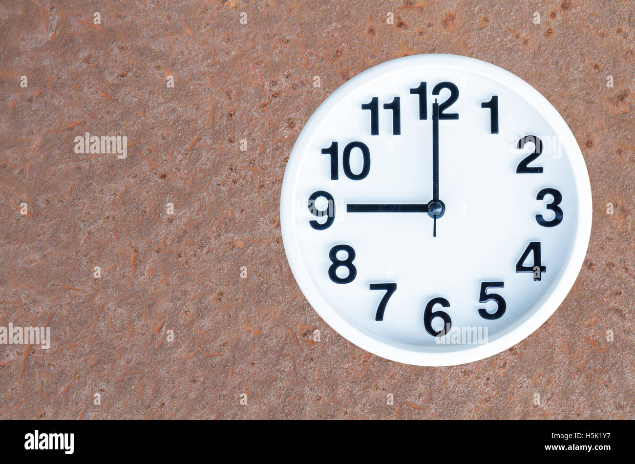 Mostra orologio 9 am o pm su acciaio arrugginito sfondo con copia spazio. tracciato di ritaglio di immagine. Foto Stock