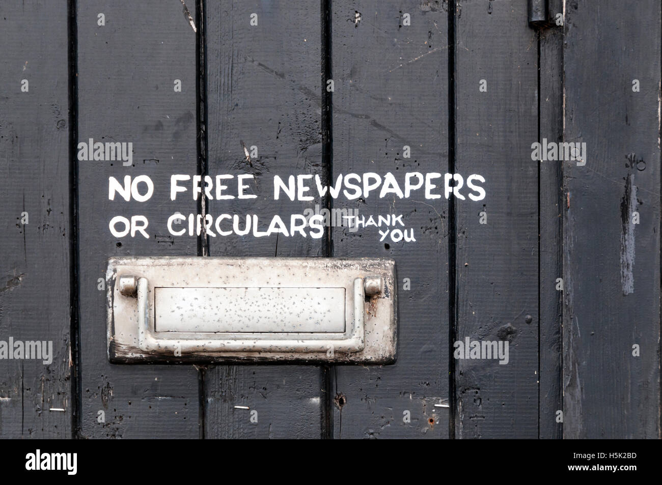Dipinto a mano della lettura del segno nessun giornali gratuiti o circolari Grazie, accanto al formato letterbox su una porta nera. Foto Stock