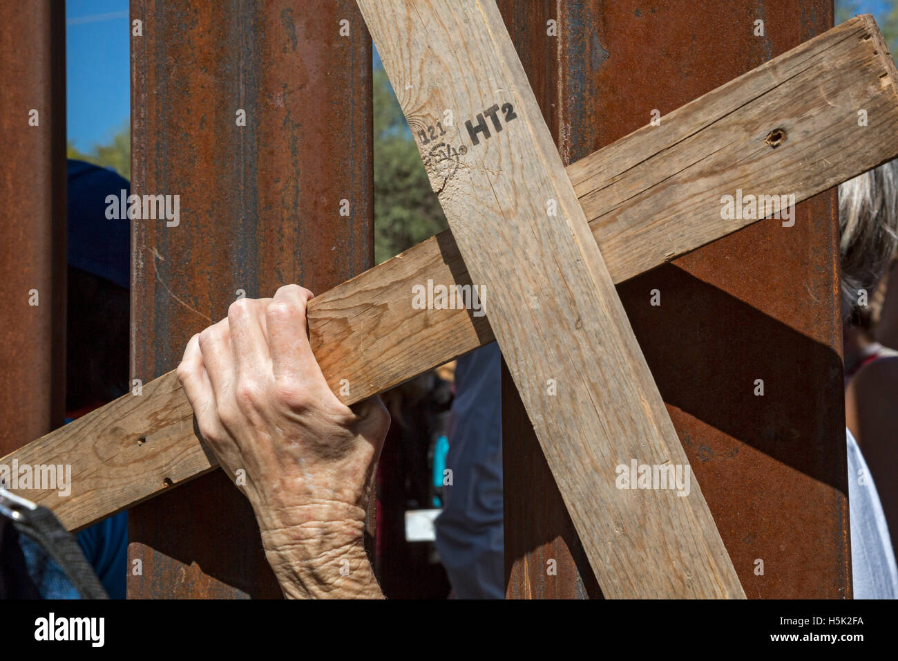 Nogales Mexico - attivisti hanno organizzato raduni di opporsi a Stati Uniti-Messico recinzione di confine. Una donna ha tenuto una croce attraverso il confine. Foto Stock