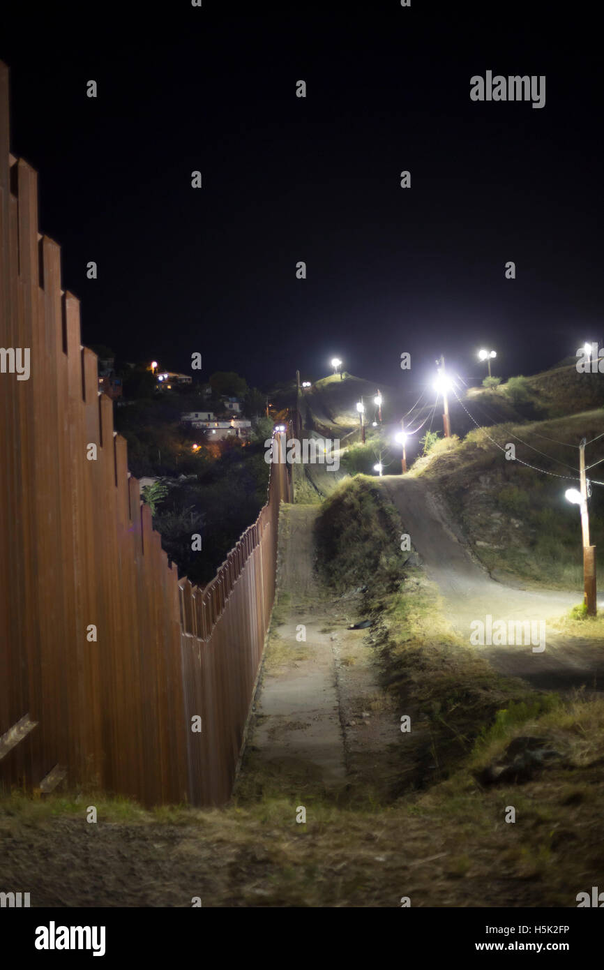 Nogales in Arizona - Stati Uniti-Messico recinzione di confine, illuminata di notte da parte del governo degli STATI UNITI Pattuglia di Confine. Il Messico è sulla sinistra. Foto Stock