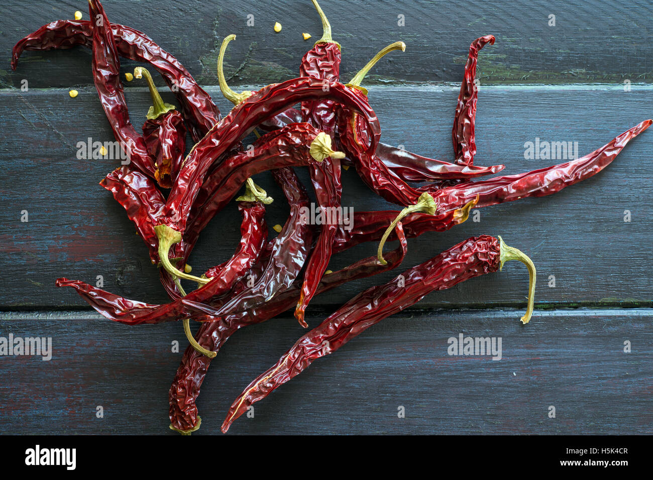 Peperoncini piccanti su una tavola di legno in nero Foto Stock