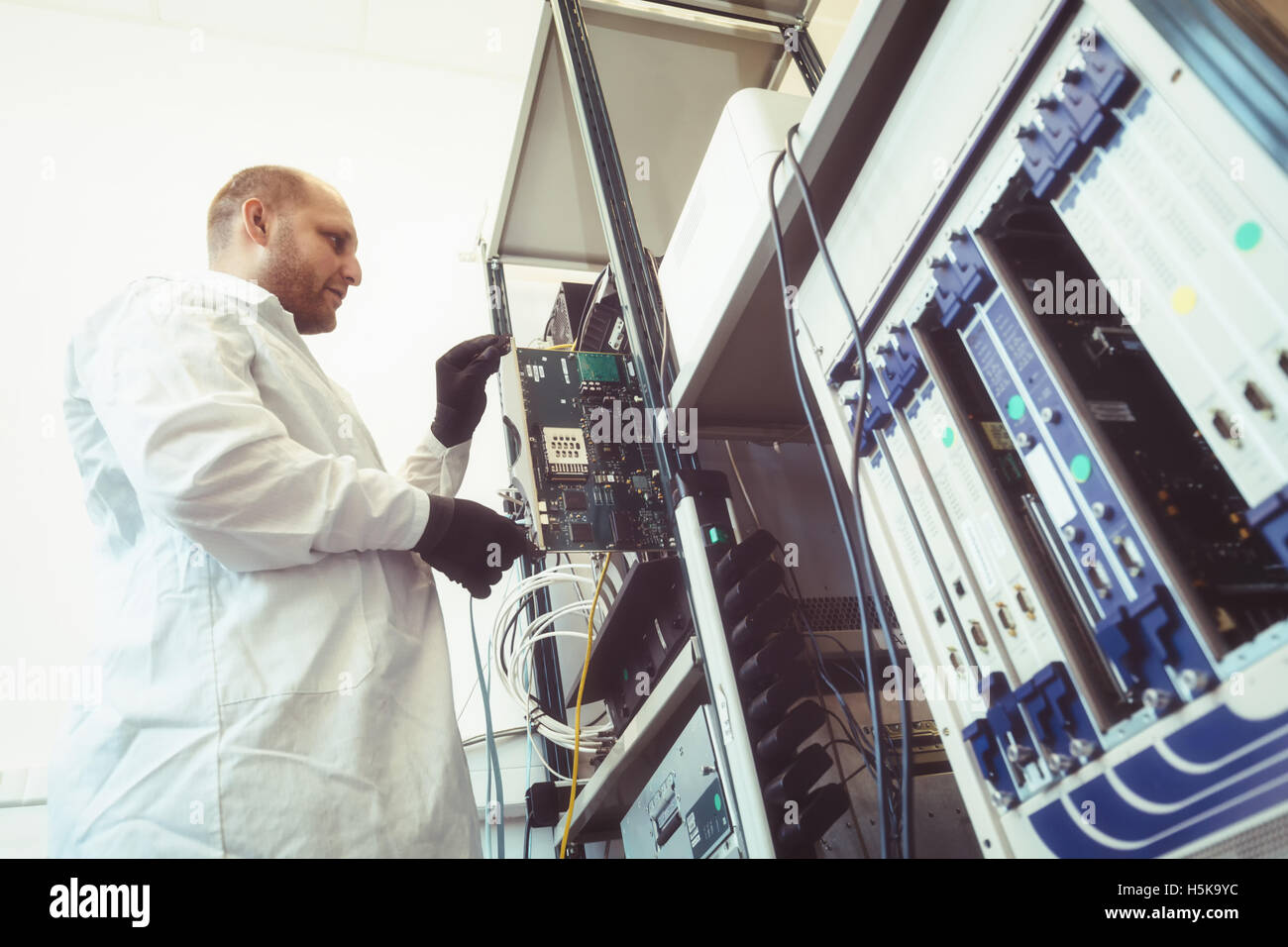 Tecnico operante nella scheda di rete labaratory Foto Stock