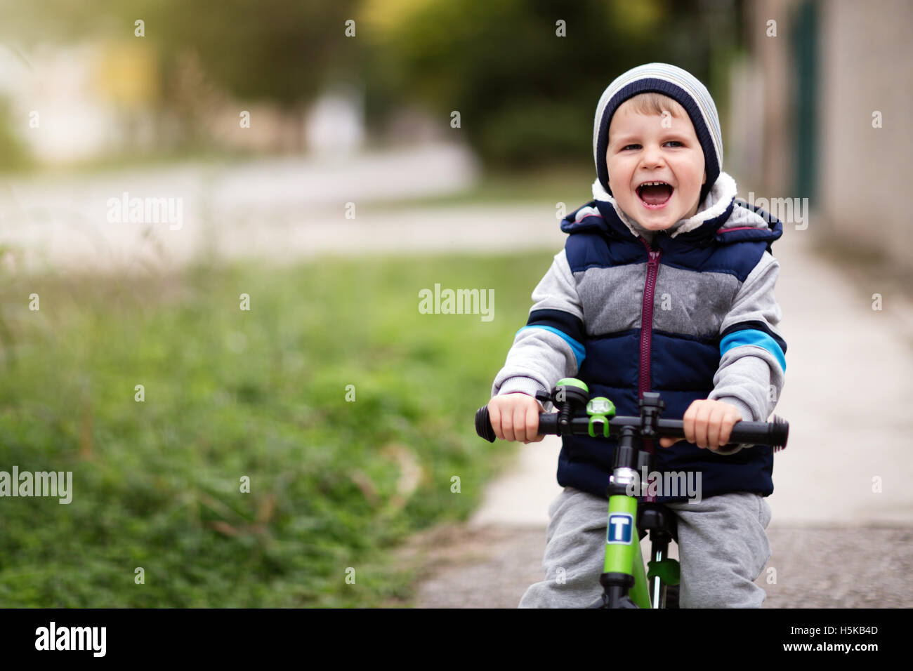 Bambino felice bicicletta equitazione all'aperto Foto Stock