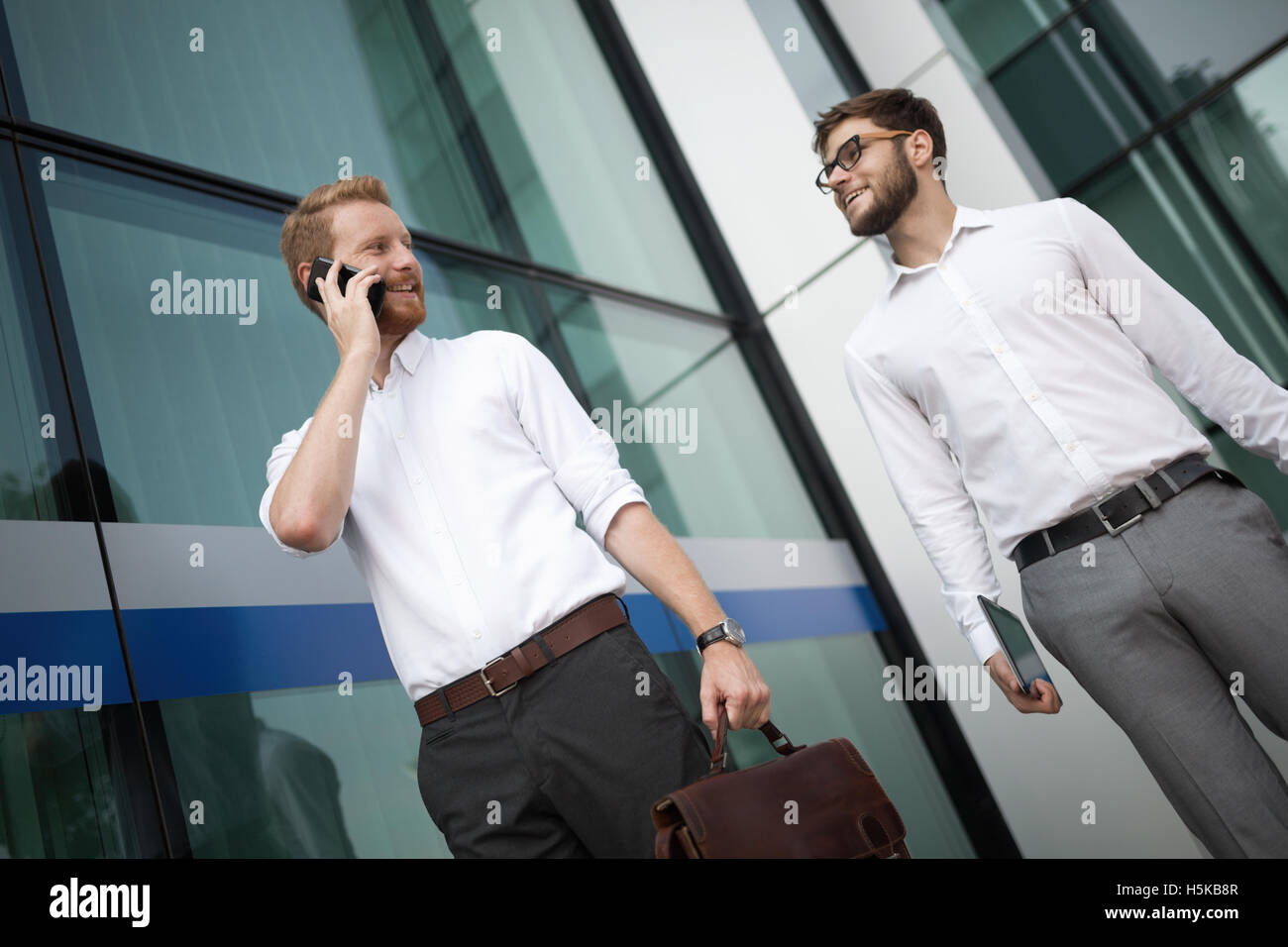 Gli imprenditori a camminare e parlare al telefono Foto Stock